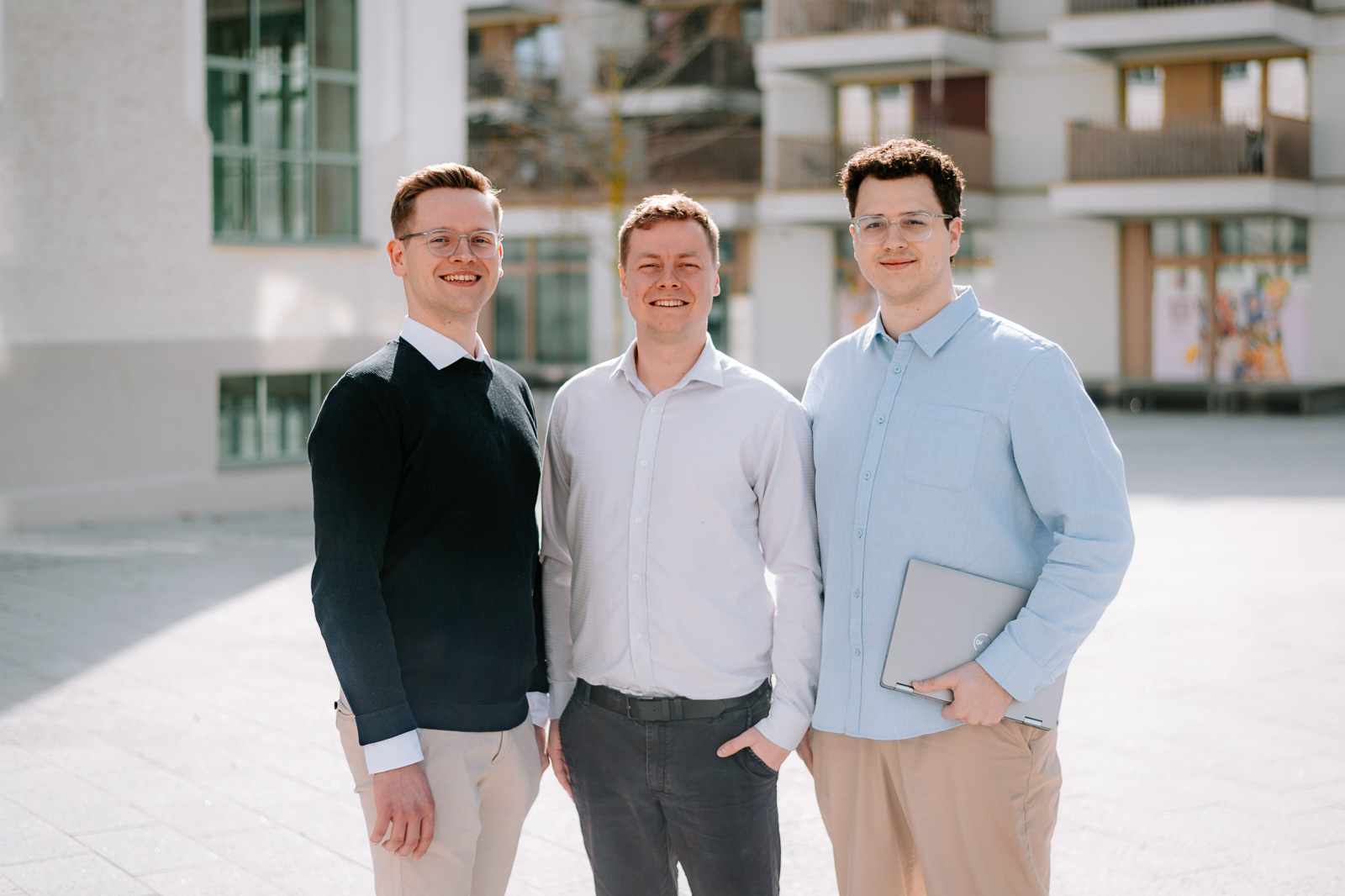 Das dreiköpfige Team von lencio steht nebeneinander im Außenbereich und blickt in die Kamera.